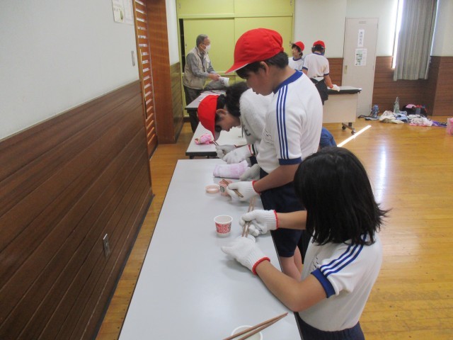 軍手2枚を装着して箸で豆を移動中